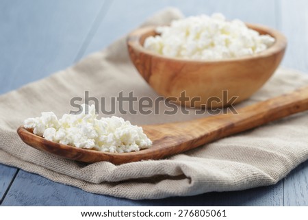 cottage cheese in wood bowl on blue wooden table
