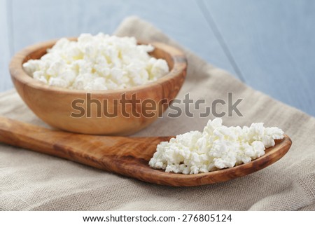 cottage cheese in wood bowl on blue wooden table