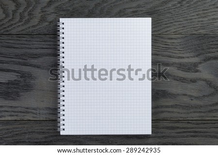 blank notepad with chequered pages on gray wood table, top view