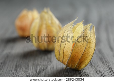Physalis fruit on oak wooden table, closeup photo