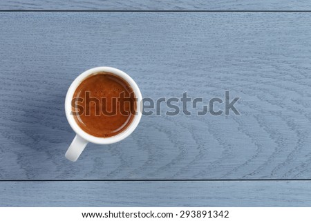 cup of fresh espresso on vintage blue table from above