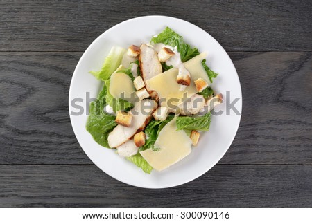 caesar salad with chicken on oak table, mediterranean food