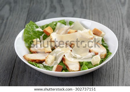 caesar salad with chicken on oak table, mediterranean food