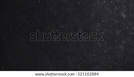 abstract particles flying over black background,dust snow or flour