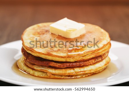 homemade pancakes with butter and maple syrup, closeup toned photo