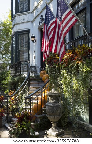 SAVANNAH, GEORGIA/USA - OCTOBER 24, 2014: Steps up to house on square with US flags in downtown. The city of Savannah was laid out in 1733 around four open squares.
