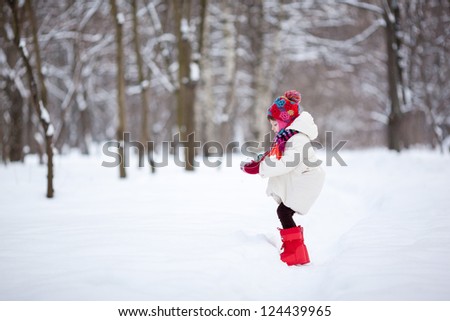 Small girl playing with snow
