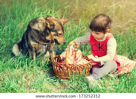 Little girl with dog on a picnic
