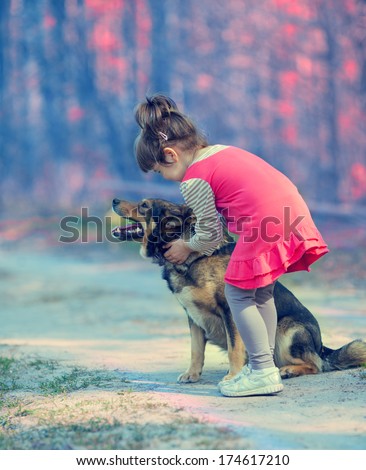 Little girl with big dog in the forest