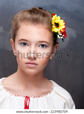Fashion portrait of beautiful girl with perfect makeup with flower in hair