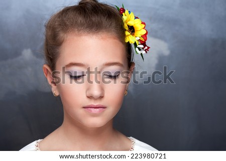 Fashion portrait of beautiful girl with perfect makeup with flower in hair