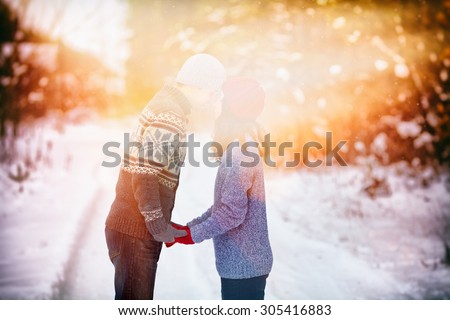 Young couple in love holding hands outdoor in winter at sunset