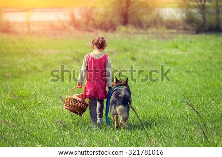 Little girl walking with dog on the meadow  back to camera