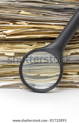 Magnifying lens  on the background of the stack of old files