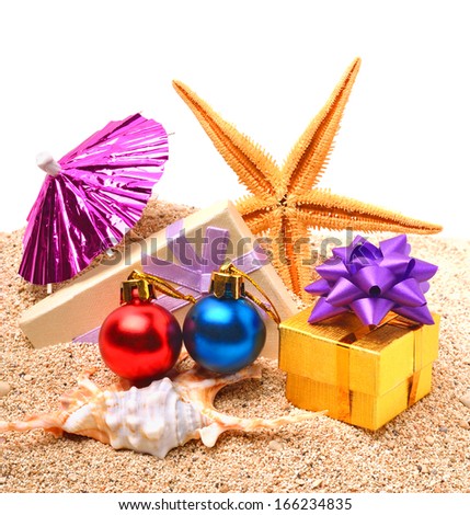 Starfish, christmas baubles, gift boxes on the sand isolated on white