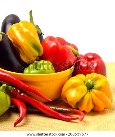 Sweet pepper, aubergine, chili pepper in the plate isolated on white