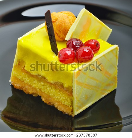 Yellow cake with cranberries on ceramic saucer.