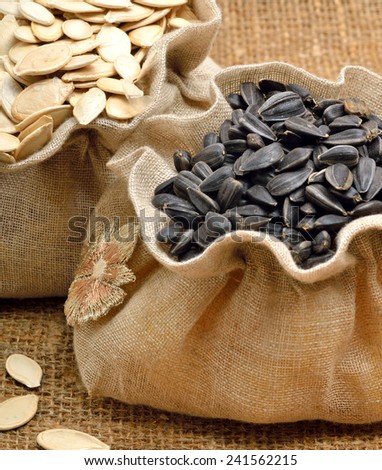 Pumpkin seeds and sunflower seeds in the bags  on sacking background
