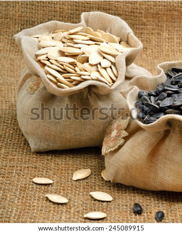 Pumpkin seeds and sunflower seeds in the bags on sacking background