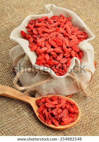 Goji berries in the sacking on a wooden background. Vitamin c fruit.
