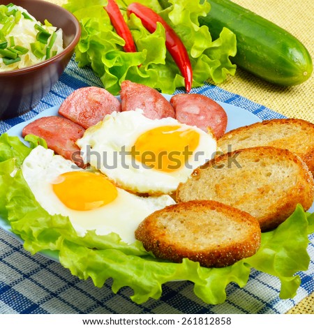 English breakfast - toast, egg, bacon and vegetables. Salad, cabbage, cucumber.