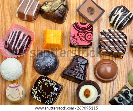 Belgian chocolate handmade chocolate candies in different shapes and colors on a wooden background