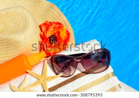 Beach hat, sunglasses, bath towel, sun spray, starfish near the swimming pool