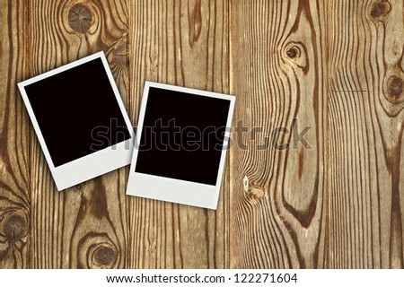 two polaroid frames on wooden background
