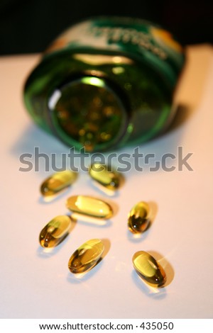 vitamins in front of a tipped jar