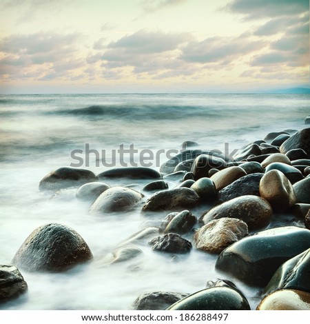 long exposure of sea and rocks and stones, teal tone