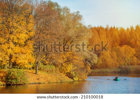 Autumn Landscape. Park in Autumn. The bright colors of fall in the park by the lake with a boat.