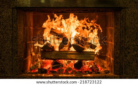 Fireplace burning. Warm cozy burning fire in a brick fireplace close up. Cozy background.