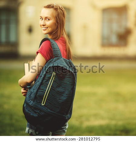 Student girl outside in summer park smiling happy. Caucasian college or university student. Young woman model wearing school bag outdoors in campus.