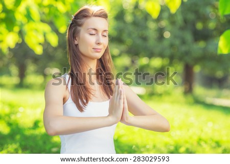 Yoga outdoors. Young woman making namaste symbol. Concept of healthy lifestyle and relaxation.