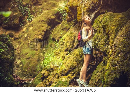 Hiking woman exploring mountain canyon. Young sportive woman wondering in the mountains.