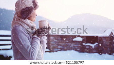 Woman drinking Hot Tea or Coffee from Festive Cup with Snowy Mountain View on Background. Beautiful Girl Enjoying Winter Morning or Evening Outdoors under the snowfall. Christmas Holidays
