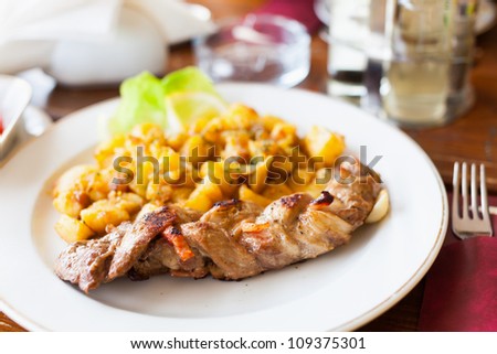 Braided pork tenderloin with baked potatoes garnish