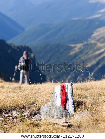 Young man walking on a marked path in the mountains
