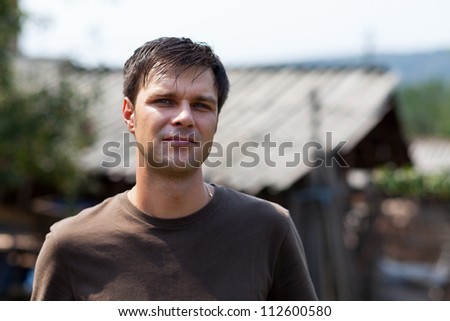 Closeup portrait of an young man outside, at countryside, in a sunny day