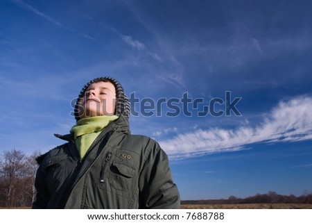 Portrait of a beautiful child with his face turned to the sun and eyes closed