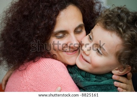 Mother and son embracing each other. Indoor scene.