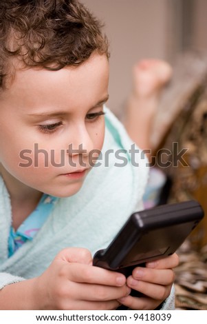 Close-up portrait of a beautiful boy playing an electronic game