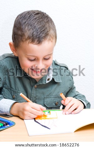 Portrait of a cute schoolboy drawing