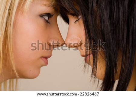 Close up portrait of two beautiful girls with opposite hair color (blonde and brunette)