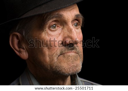 Portrait of an old man with hat, isolated on black