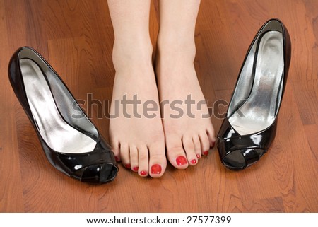 Woman feet with shoes nearby
