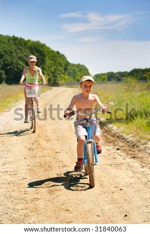 Mother and son riding bicycles on a country road