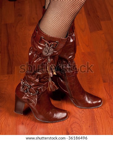 Woman legs in maroon leather boots