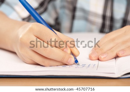 Close up of a hand of a pupil writing homework or examination