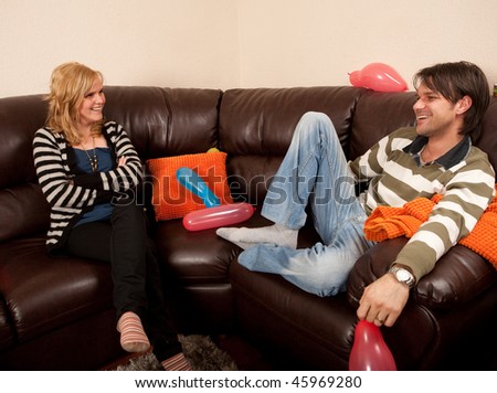 Two people chatting on the sofa at a party